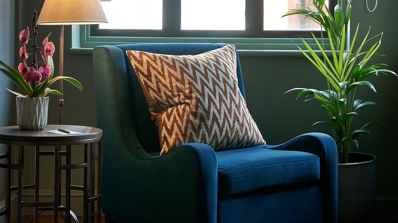 Elegant lounge chair by a window, featuring Early Bird Offer at The Capital Townhouse