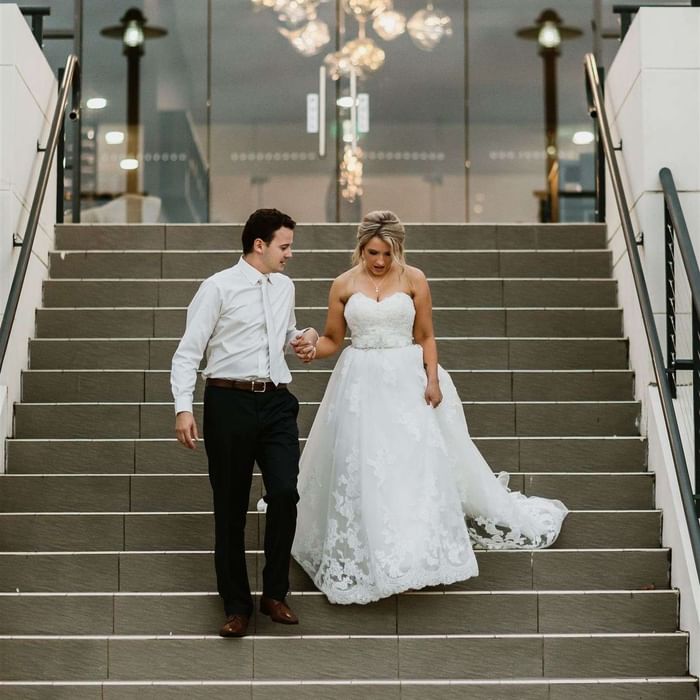 Wedding couple walking downstairs at Mercure Kooindah Waters