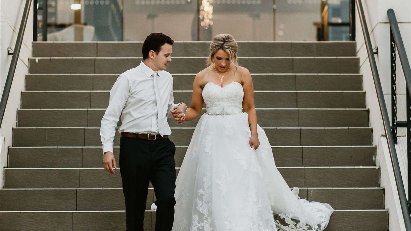 Wedding couple walking downstairs at Mercure Kooindah Waters