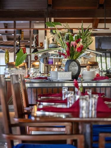 Buffet dining area featuring wooden furniture and large varse in Lagoon Terrace Restaurant at warwick le lagon vanuatu