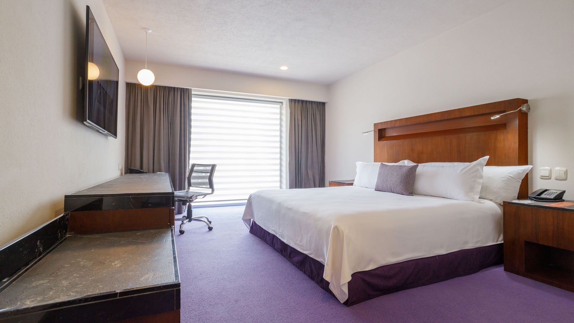 King Deluxe room featuring a king bed, work desk, and purple carpet  at Camino Real Pedregal Mexico