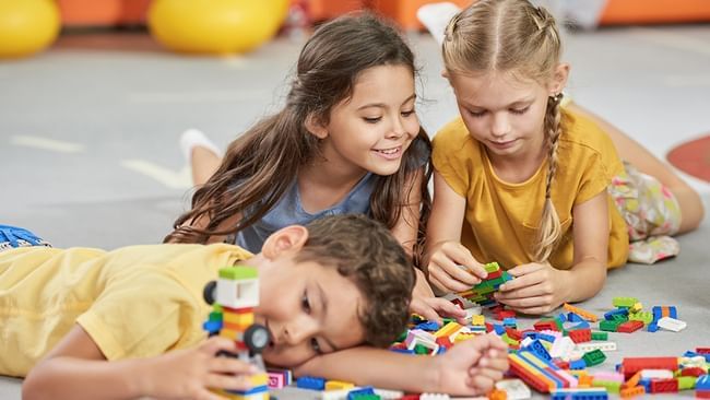 Tres niños jugando con Legos en Live Aqua Resorts