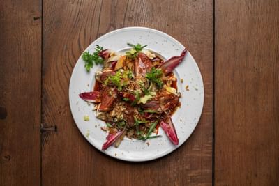 A plate of food on a wooden table served in a Restaurant at The Sparrow Hotel