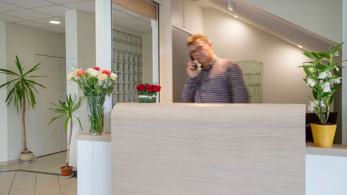 A receptionist at the reception desk in Le Clos de l'Orgerie