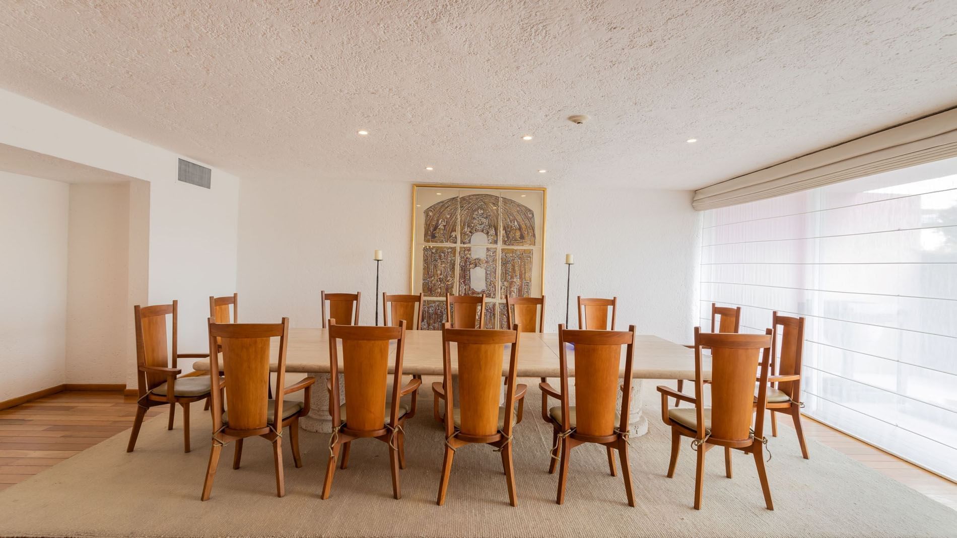King Presidential Suite with a long marble table, wooden chairs, and classic artwork at Camino Real Polanco Mexico
