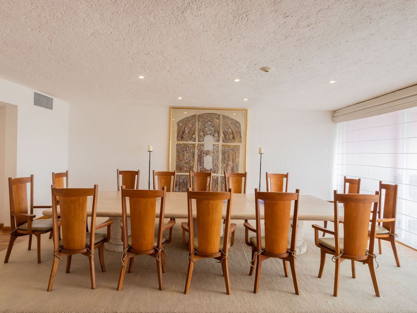 King Presidential Suite with a long marble table, wooden chairs, and classic artwork at Camino Real Polanco Mexico