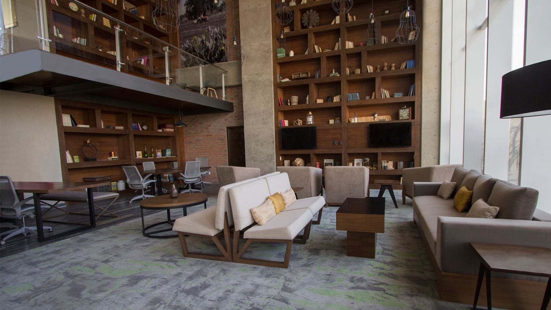Elegant lobby area with large book shelves at Fiesta Inn Suites Aeropuerto del Bajío