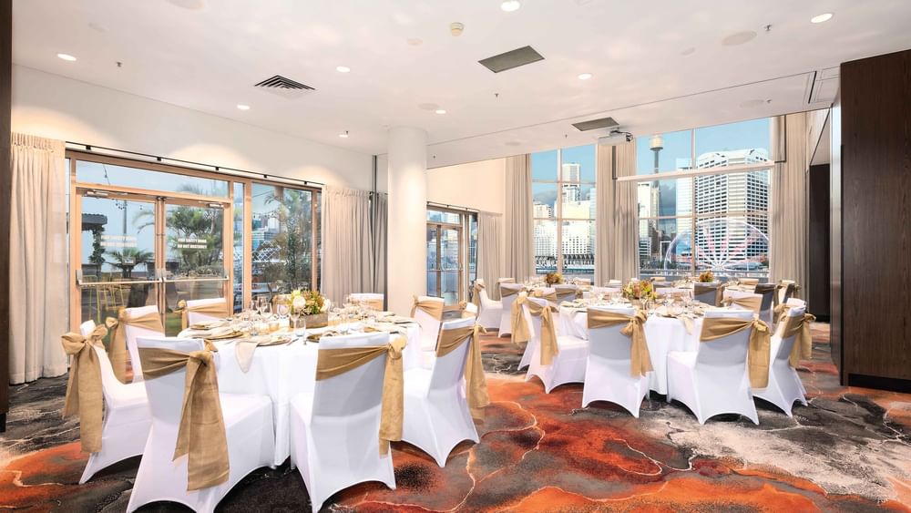 Banquet set-up with city views and elegant decor in The Hunter Room 1-4 at Novotel Sydney on Darling Harbour