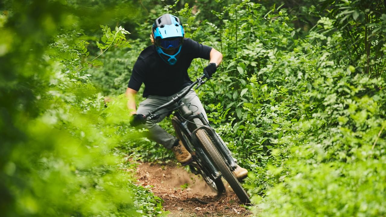 mountain biking zipping down a forest trail