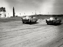 Black and white photo of early drag racers.