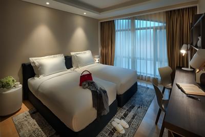 dimly lit guestroom with two twin beds combined