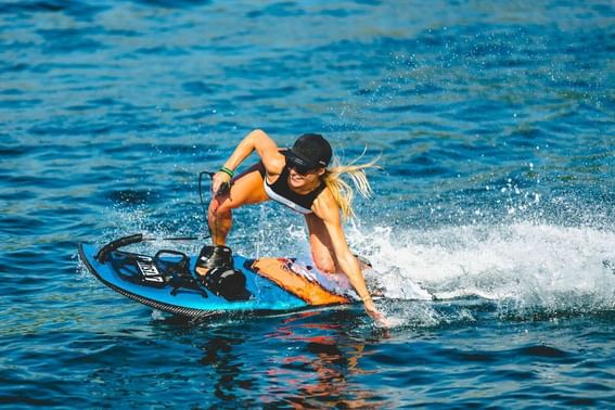 A woman enjoys wakeboarding on the water near Grand Park Kodhipparu, Maldives