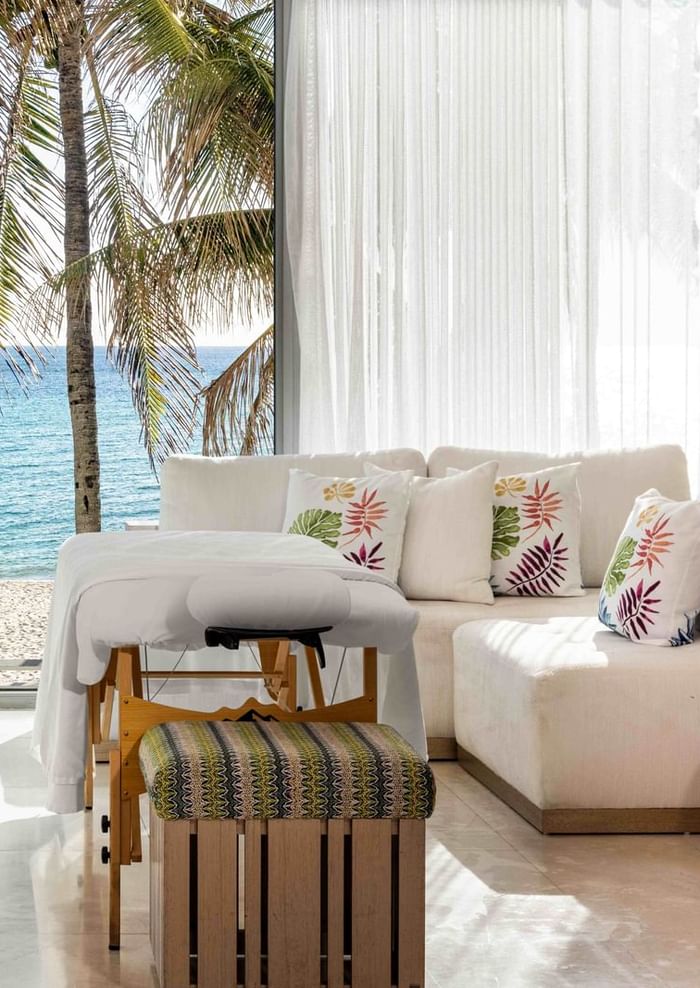 Interior of a suite at The Diplomat Resort featuring massage tables and a stunning ocean view through large windows