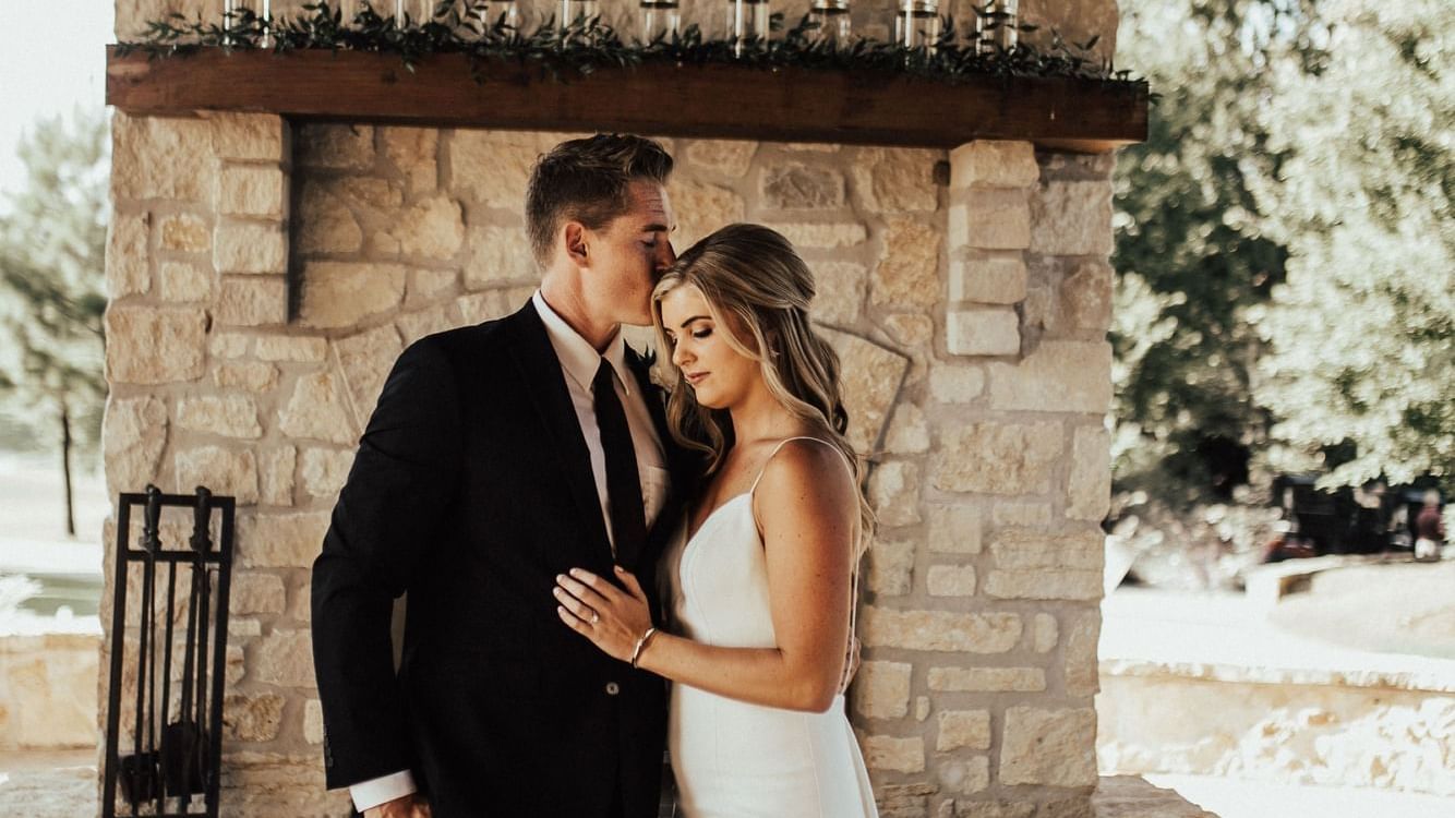 Couple in formal attire embracing in front of a stone structure on the North Patio at Shangri-La Monkey Island