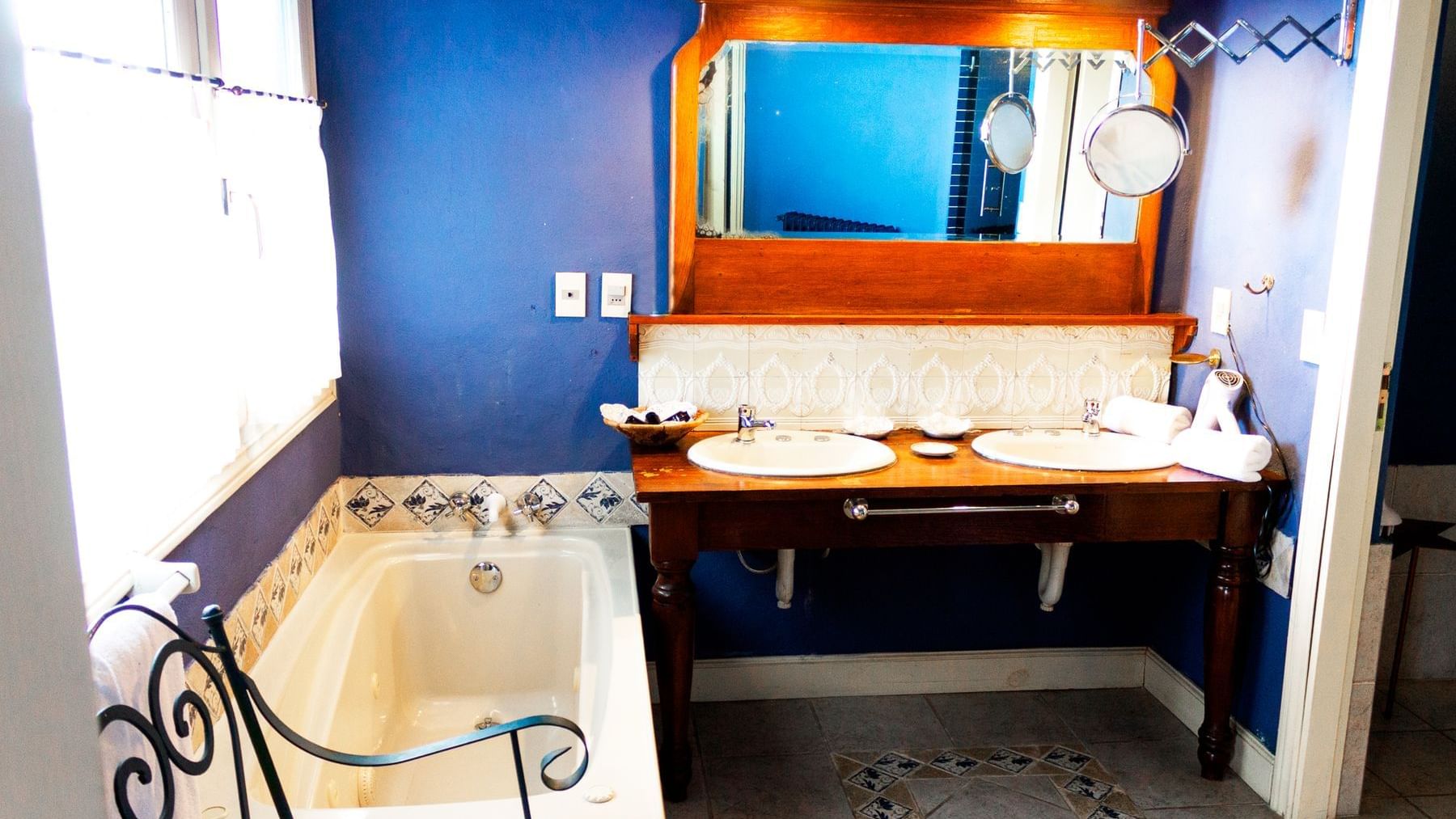 The Suite bathroom with double sinks & bathtub at DOT Hotels
