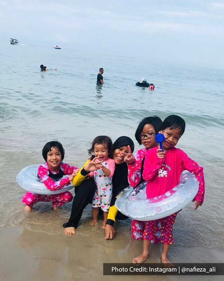 a group of children standing on a beach shore