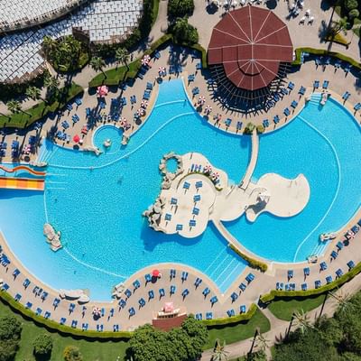 Aerial view of large pool & deck chairs, Falkensteiner Hotels