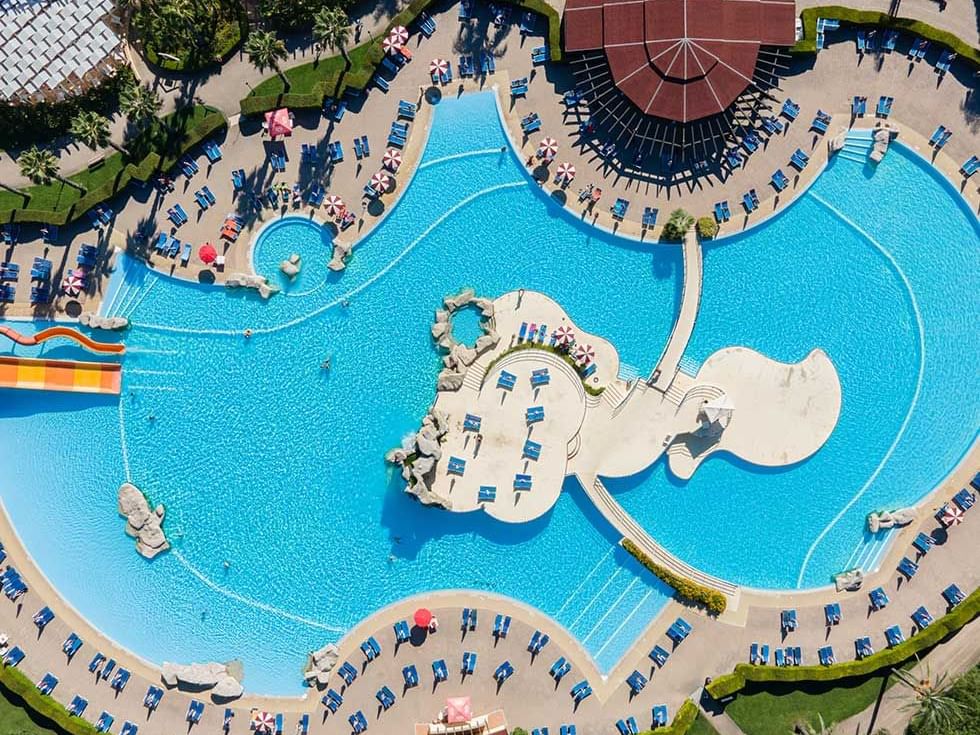 Aerial view of large pool & deck chairs, Falkensteiner Hotels