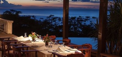 Restaurant table overlooking Tobago bay at sunset