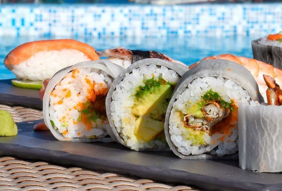 Closeup of California Rolls on a table by a pool at The Reef 28