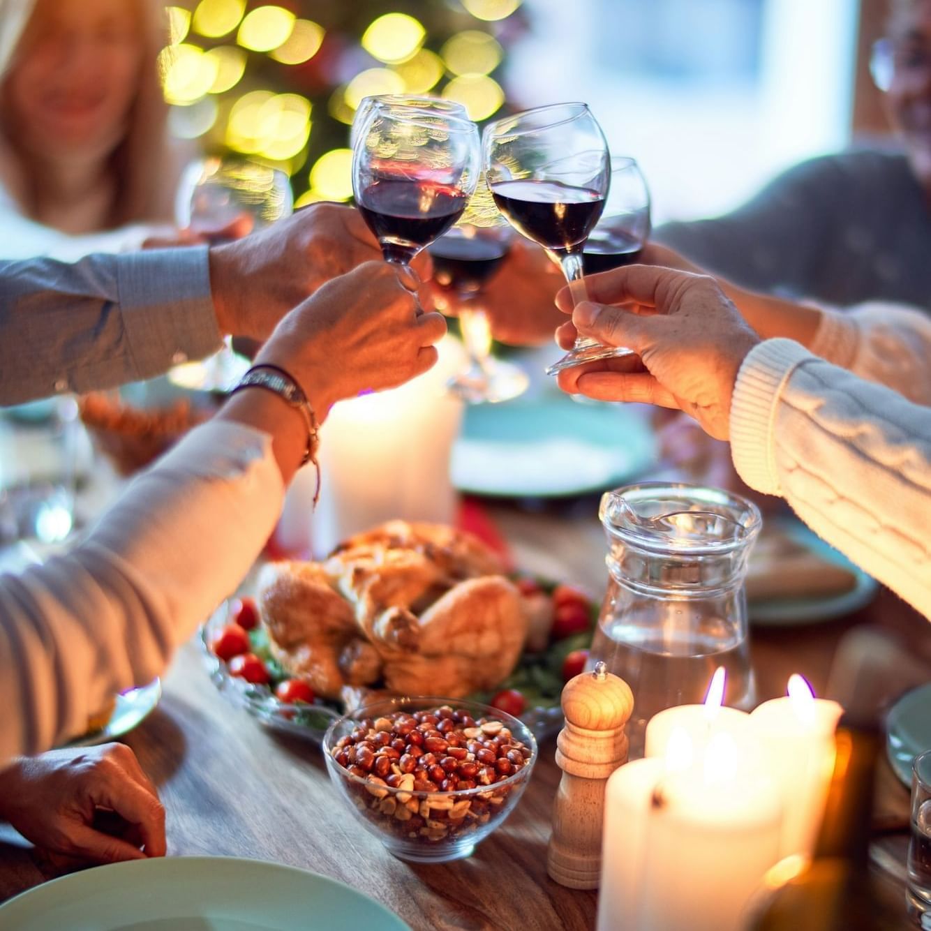 People toasting with red wine over a festive table in The Lodge at Schroon Lake