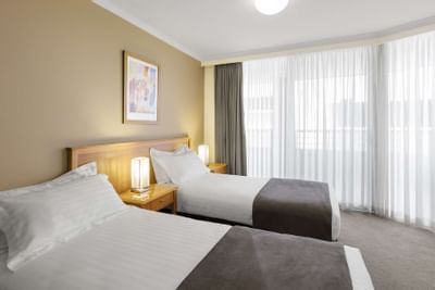 Twin beds & night lamps 2 Bedroom Apartment at Nesuto Hotels