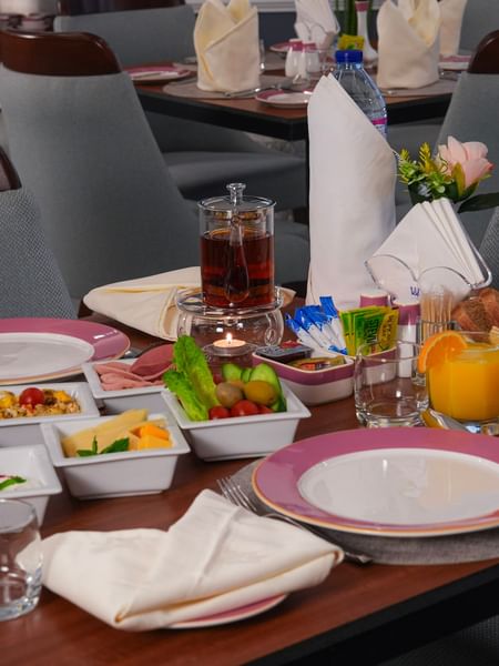 Breakfast table with various dishes, bread, and drinks at Warwick Hotel & Spa - Jeddah.