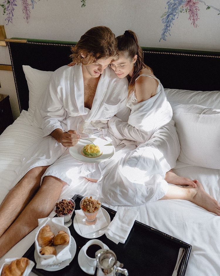 A couple having breakfast on bed at Brazilian Court