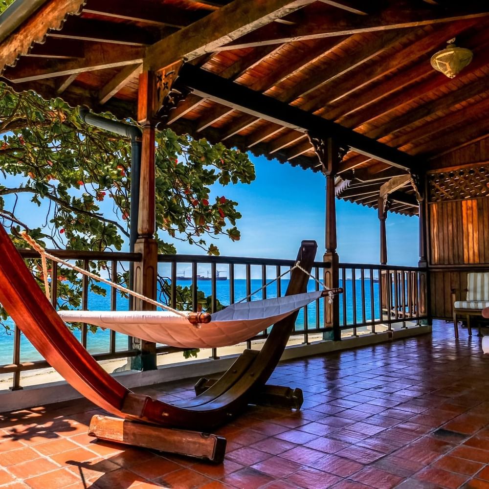 Wooden hammock on porch overlooking ocean at Zanzibar Serena Hotel in Zanzibar.