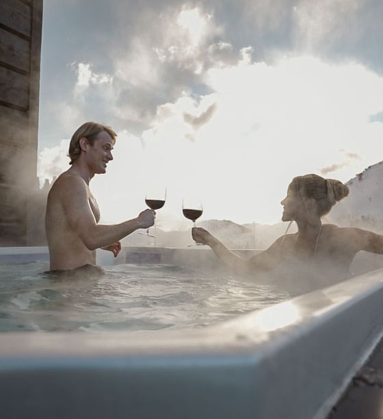 Couple enjoying wine in a jacuzzi outdoors at Hotel Jackson