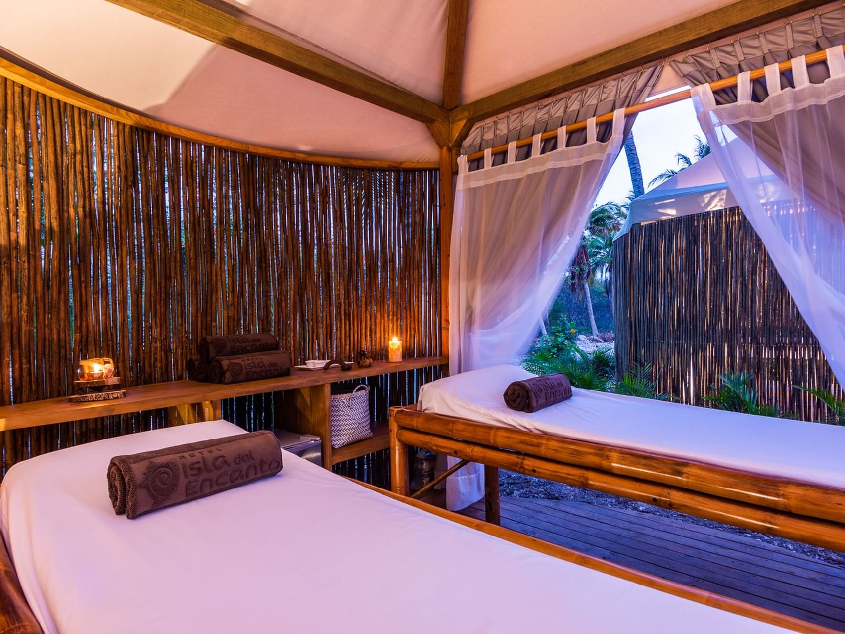 Two spa beds in a cozy bamboo hut with candles in spa at Hotel Isla Del Encanto