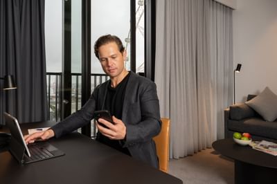 A man looking at his phone while working at Nesuto Docklands