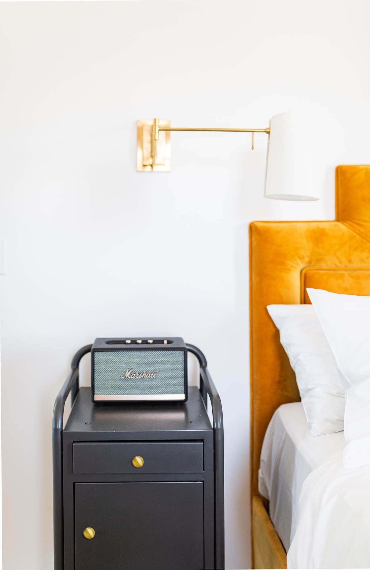 table next to bed with orange headboard