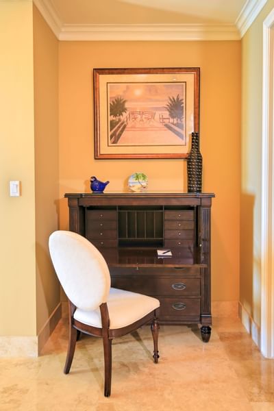 A chair, wooden cabinet and a wallpaint at Windsong Resort On The Reef