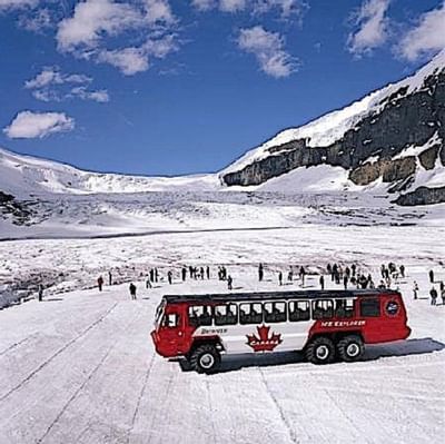 People getting off a snow bus in Athabasca Glacier with a mountain backdrop near Blackstone Mountain Lodge