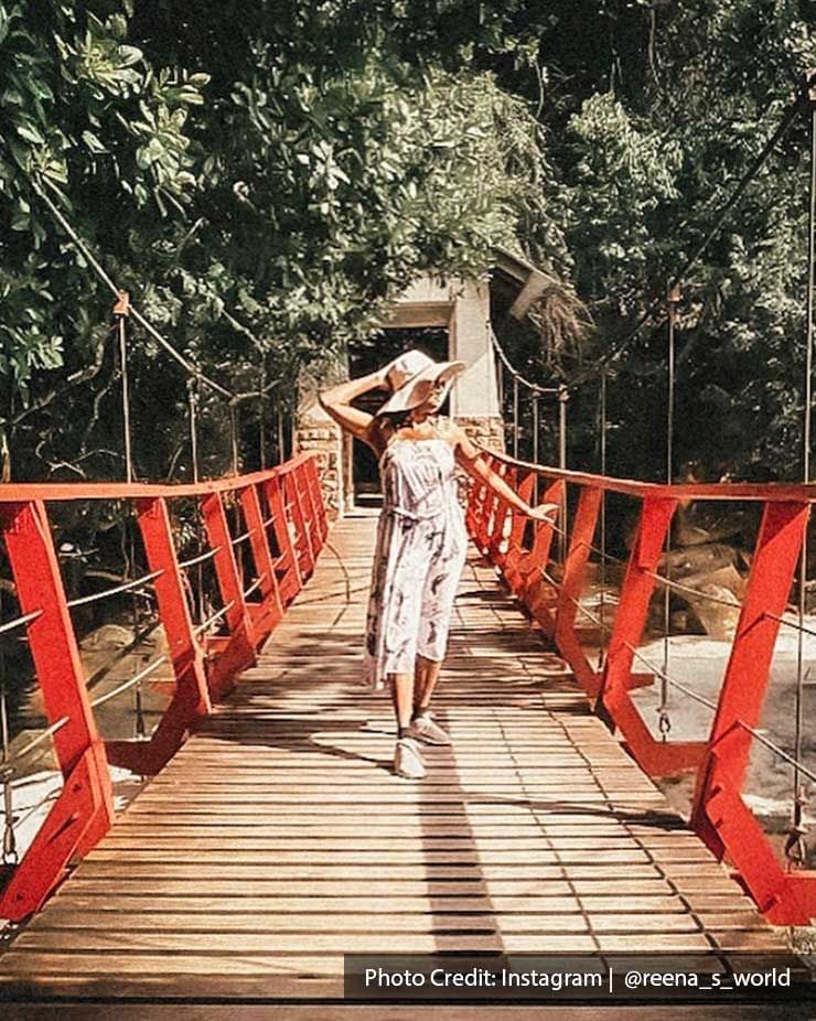 A lady was standing on a wooden bridge in Penang National Park - Lexis Suites Penang