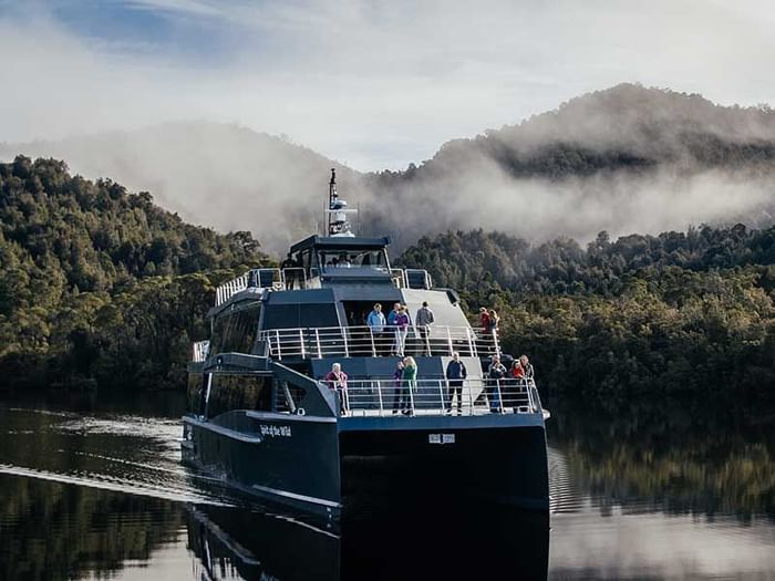 Gordon River Cruises navigating through calm water near Strahan Village