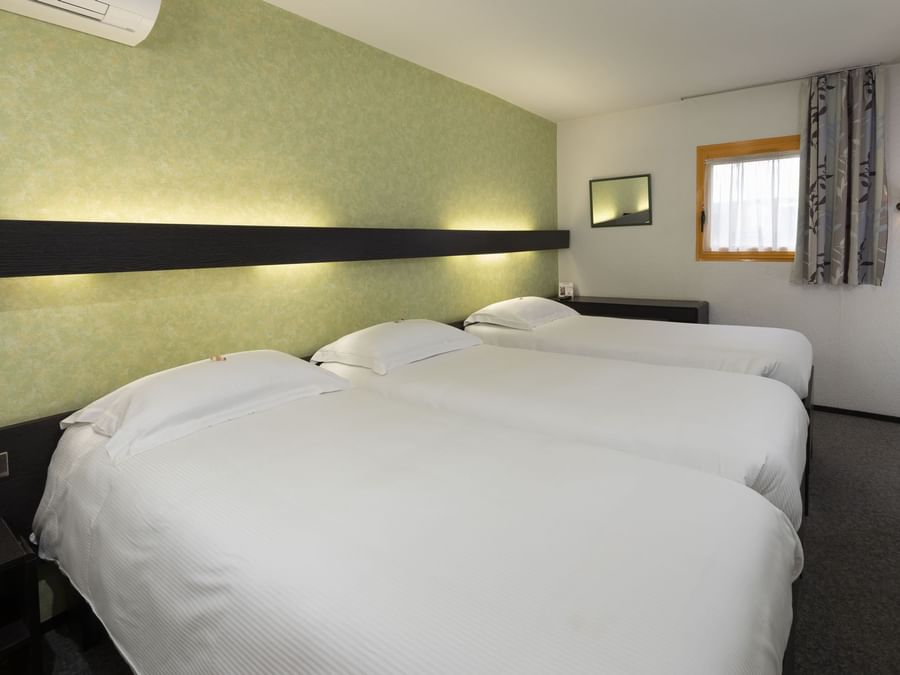 Three beds in a room at Hotel Bourges North