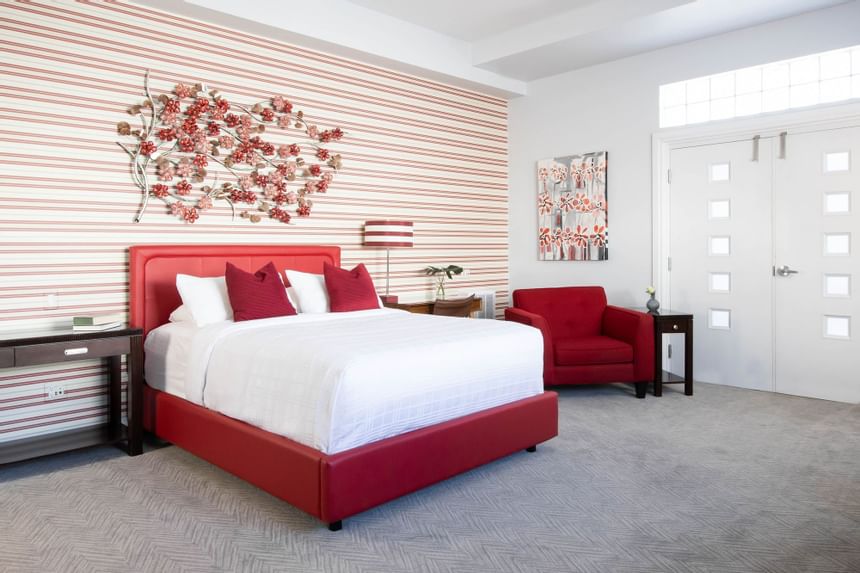 queen bed suite with balcony doors in view and red metal flowers