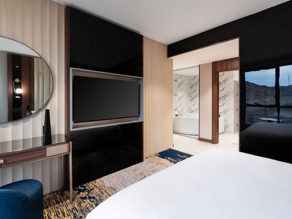 Modern room interior with a bed facing the TV  at Warwick Hotel Al Taif