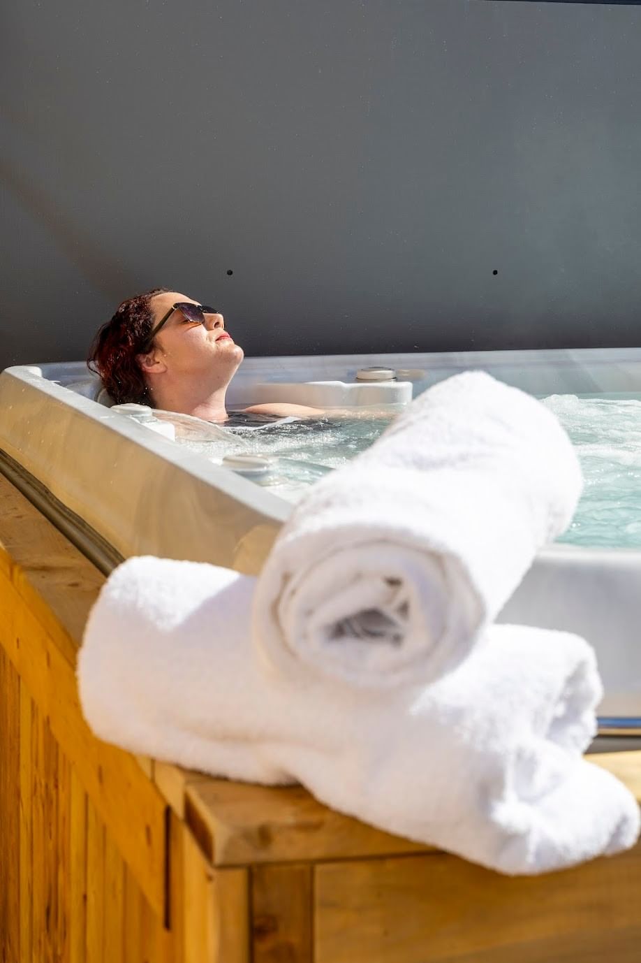 Woman with sunglasses in outdoor hot tub jacuzzi at best places to stay in moncton new brunswick Rodd Moncton