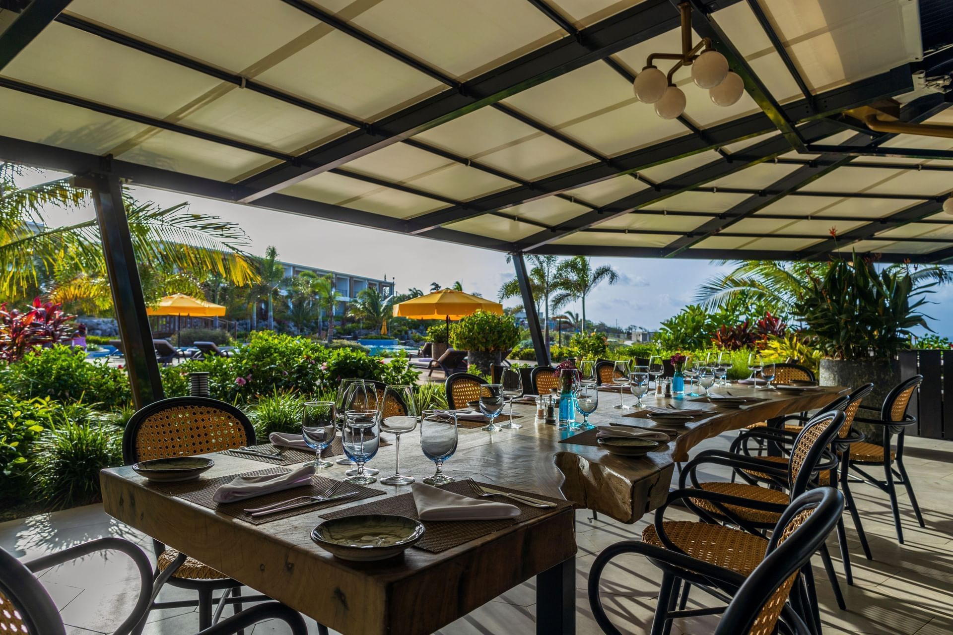 Eetruimte gedekt met glaswerk en borden, omringd door weelderig groen in het Breeze Restaurant bij Golden Rock Resort
