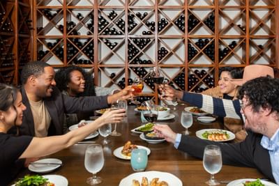 People toasting glasses on the dining table in The Wine Room at Alderbrook Resort & Spa