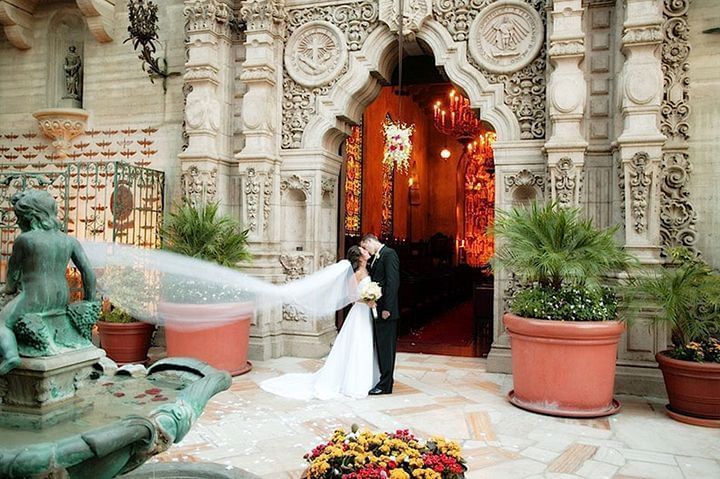 Bride and Groom kissing in front of entrance to St. Francis of A