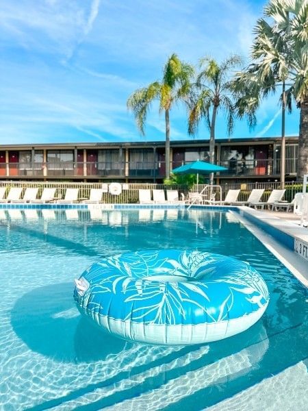 A blue float laying in a sparkling blue swimming pool at Rosen Inn International, an affordable Orlando hotel with family-friendly amenities.