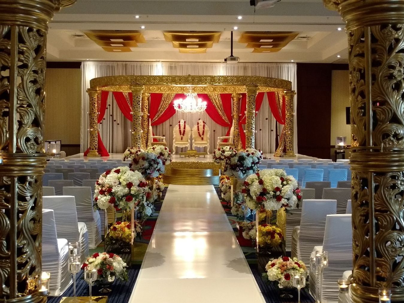 wedding aisle with flowers and chairs facing altar