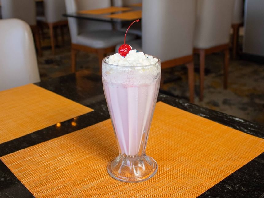 Batido cremoso con nata montada y cereza, servido en el interior de Cafetería Palmira de Araiza Calafia