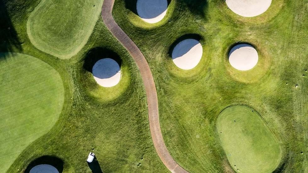 High-angle view of a golf course with sand pits near Falkensteiner Hotels and Residences