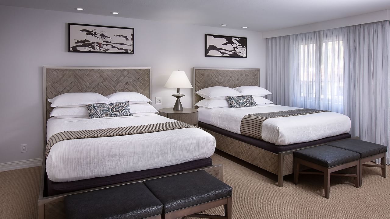 Hotel guestroom featuring two beds and a nightstand
