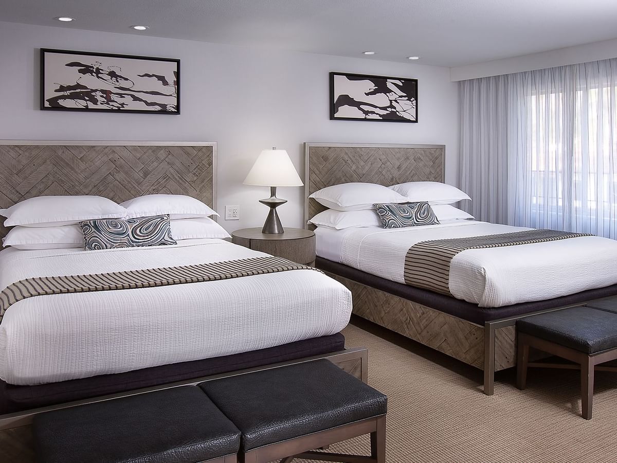 Hotel guestroom featuring two beds and a nightstand